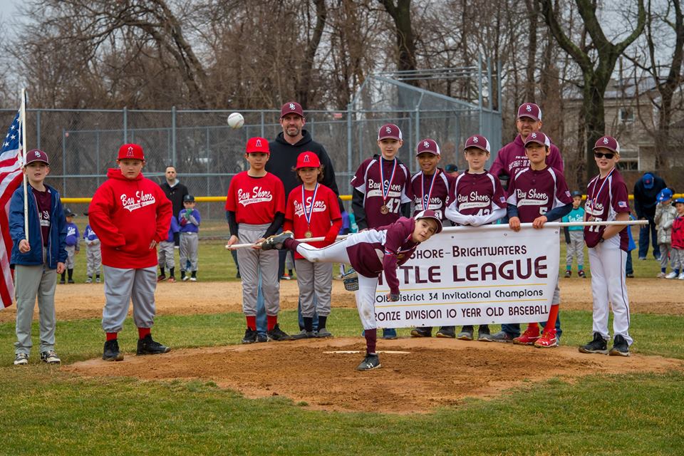 Little League player throws out a pitch at opening game.