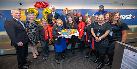 Supervisor Carpenter stands with employees of Southwest Airlines at the twenty year celebration of the airline at MacArthur Airport.