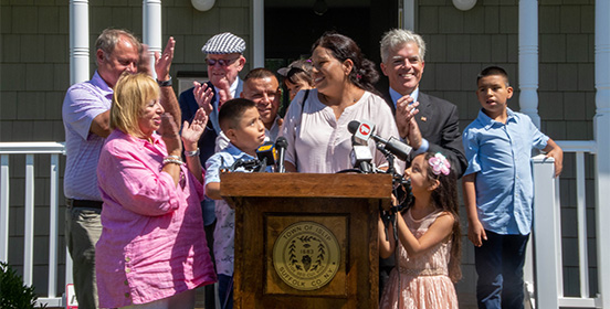 Elected officials stand with the family who received the keys to their new house  