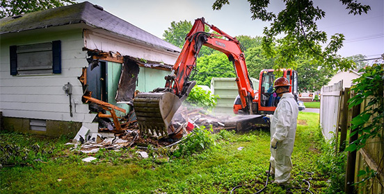 Unsafe structure is torn down off of a boarded up home in West Islip