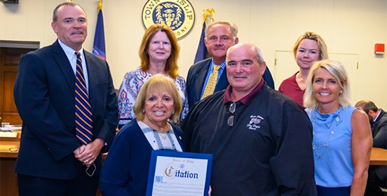 Supervisor Carpenter and the Islip Town Board pose for a photo in the Town Board Room with Guy Leggio 