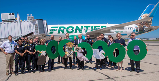 Elected officials, representatives of Frontier and ISP workers pose with a 1,000,000 sign in front of one of frontier's airplanes