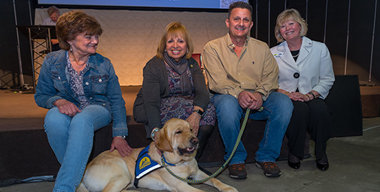 Supervisor Carpenter sits with Paul Monfre who received Valor VII the service dog 