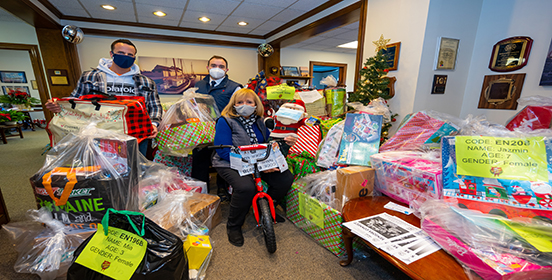 Supervisor Angie Carpenter is joined by workers from the Salvation Army who were there to pick up the bundles of gifts that surround them