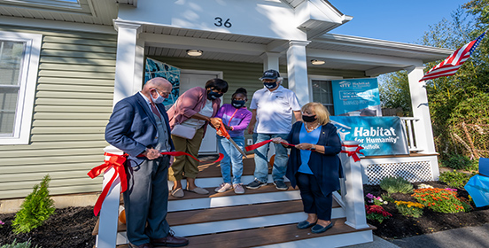Supervisor Angie Carpenter stands with the Williams family and Habitat for Humanity at the ribbon cutting for their new home.