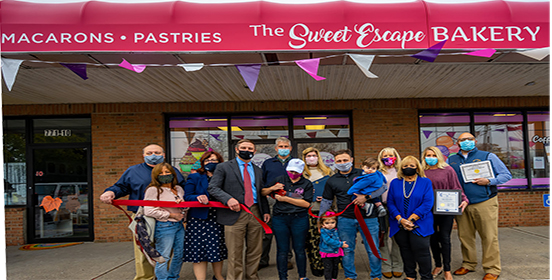 Supervisor Angie Carpenter is joined by the bakery’s owner, family members of the owner, bakery staff, Chamber of Commerce members and other elected officials to congratulate the opening of the new Sweet Escapes Bakery in Bayport at the ribbon cutting ceremony. 