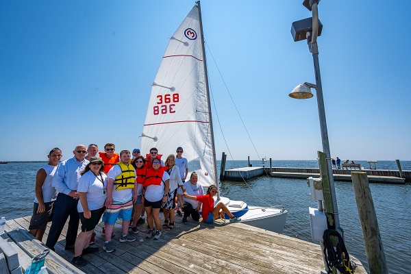 town supervisor Angie Carpenter and Tom Owens stand with students and instructors of the Wet Pants Sail Association for the Sachem Share Day event. 