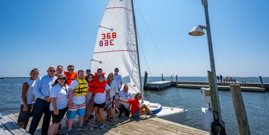 town supervisor Angie Carpenter and Tom Owens stand with students and instructors of the Wet Pants Sail Association for the Sachem Share Day event. 