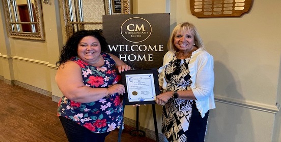 Supervisor Carpenter stands with Alyse Arpino, Executive Director of CM Performing Arts. The supervisor presents Alyse with a certificate to commemorate the re-opening of the performing arts center since the COVID-19 pandemic began.
