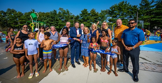 supervisor carpenter and members of the town board are joined by members of the community and commissioners from the Parks Dept and Public Safety Dept to celebrate the official opening of the Spray Park at Roberto Clemente Park