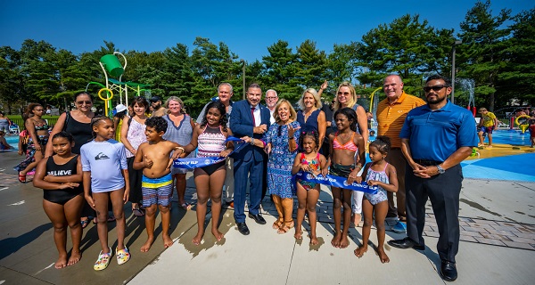 supervisor carpenter and members of the town board are joined by members of the community and commissioners from the Parks Dept and Public Safety Dept to celebrate the official opening of the Spray Park at Roberto Clemente Park