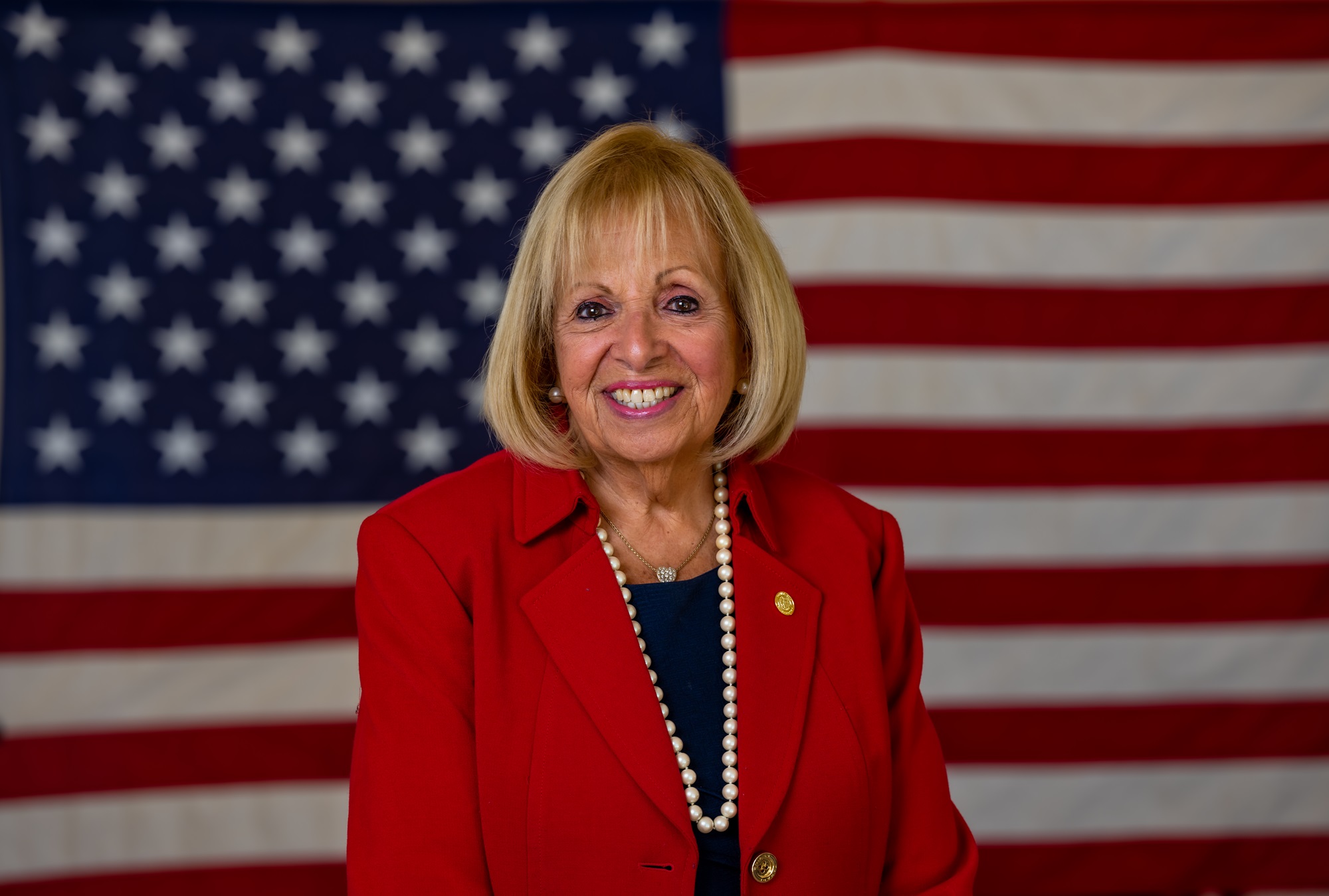 Angie Carpenter in red, with USA Flag background
