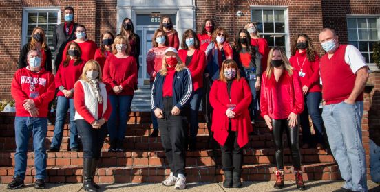 employees wearing red line the steps outside Town Hall