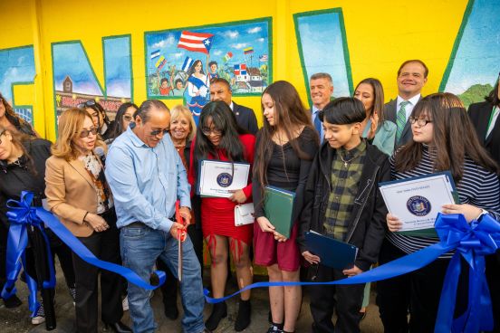 Group Photo of Ribbon being cut in front of the new mural