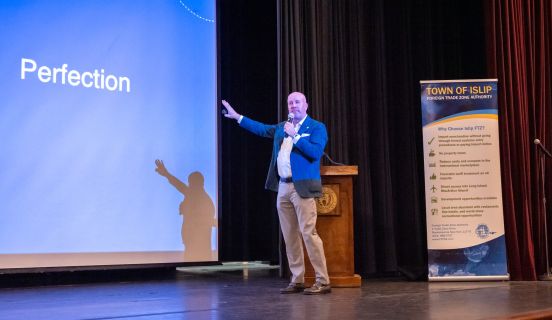 Brian Parsley pointing toward the powerpoint on display as he leads talk