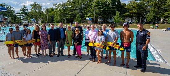 Supervisor, local officials, staff in group photo by pool