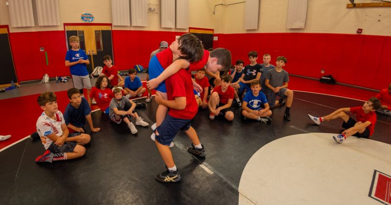 one wrestler lifts other preparing for controlled takedown