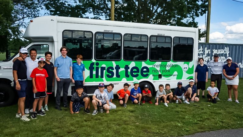 Kids in front of the first tee vehicle