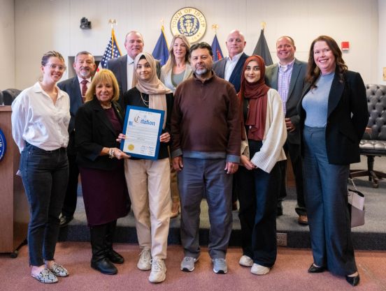 student in group photo with Town Board and award