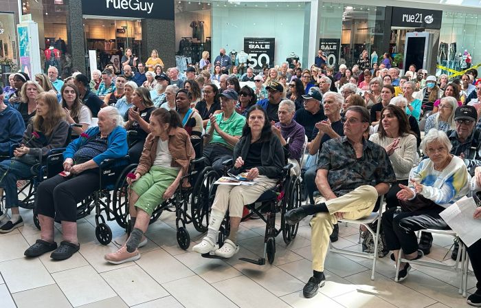 Crowd of Seniors, sitting, packed tight at mall exhibit