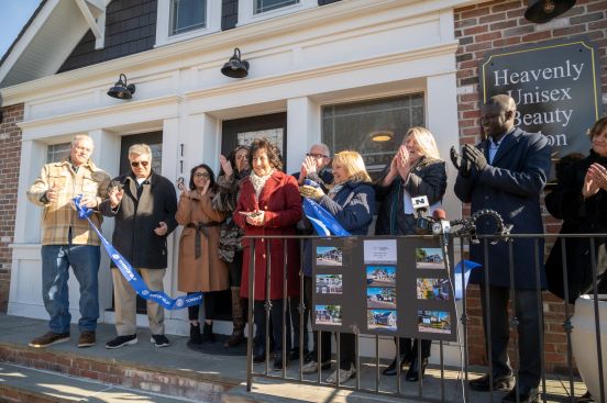 Group photo with state and local officials and property owner as they cut the ribbon