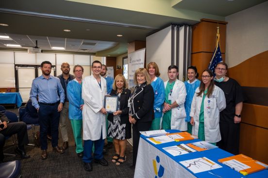 Group photo with medical officials and Town Supervisor presenting certificate