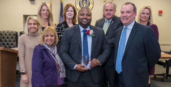  An image of the Islip Town Board and Brandon Bell posing for a photo in the Islip Board Room, having recognized Brandon at the Islip Black History Month Celebration.