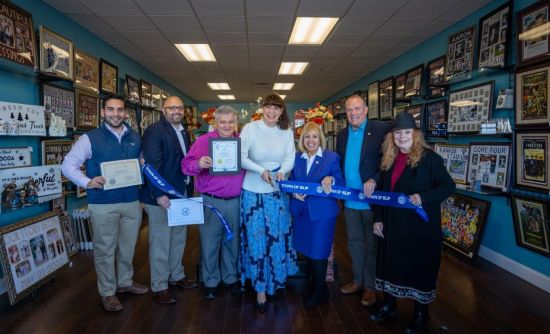 Supervisor and Councilman holding ribbon with business owners