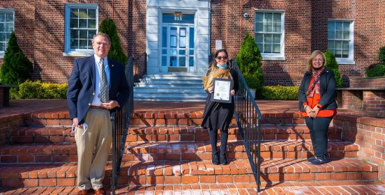 Supervisor Carpenter, Councilman O'Connorr and Isabella Costello pose with recognition award on Town Hall Steps