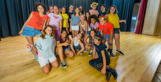 The theater students huddle together and flash their best pose for the camera, smiles abound.