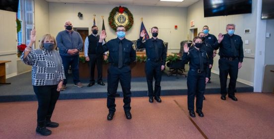 Supervisor Carpenter, Public Safety Officials and Cadets in group photo with right hand raised.