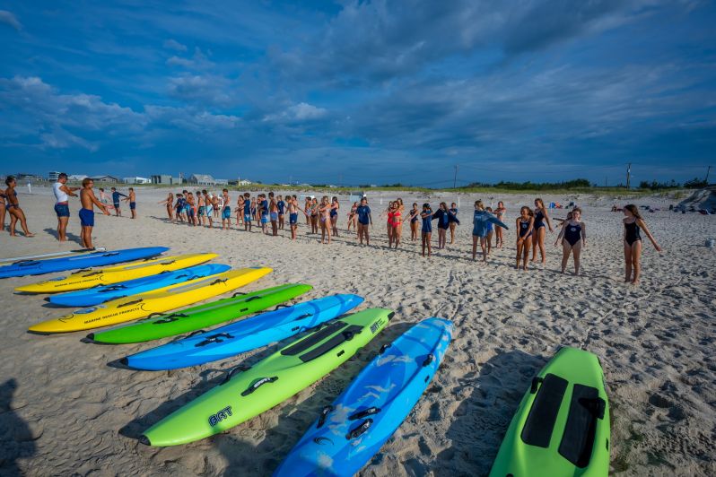 kayaks lined up on sand during demonstration