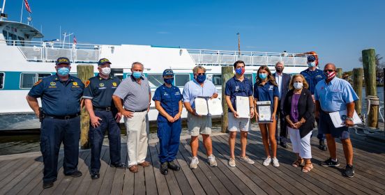 Supervisor Carpenter, Councilman Cochrane, Senator Boyle, members of Coast Guard pose on doc with awards.