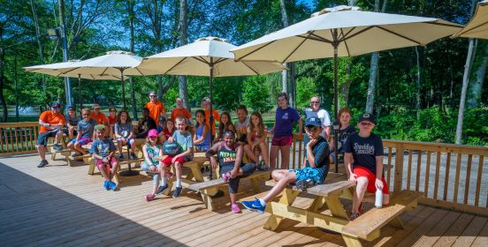 Camp kids line the deck of the new facilities under brand new picnic tables and umbrellas.