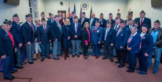 Supervisor Carpenter, the Islip Town Board, and all honored veterans stand in a ring infront of the town board room, posing for a large group photo.
