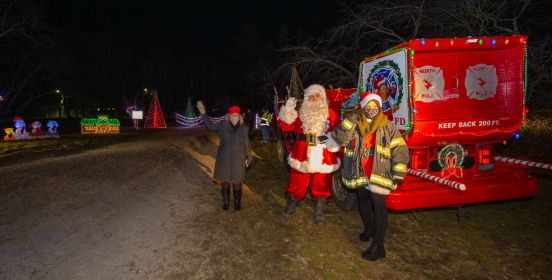 Supervisor Carpenter next to Santa waves on visitors