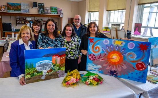 Supervisor Carpenter, joined by members of Senior Citizen Services and the DiMola family, holding works of art