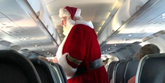 A very official looking Santa walks the isles of the flight.