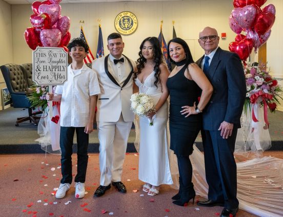 bride groom and family in group photo with decorative items all around.