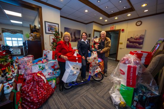 Supervisor and Salvation Army reps group photo with toys in Sup's Office.