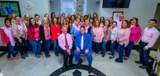 Town Supervisor Angie Carpenter, members of the Islip Town Board, as well as many members of TOI staff and employees, pose for a photo outside the Town Board room, wearing their pink in support of the cause.