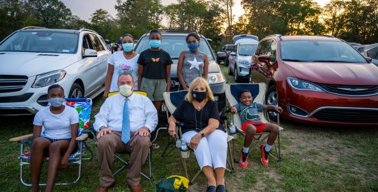 Supervisor Carpenter and Councilman O'Connor pose for photo with kids in attendance to watch film, masks on.