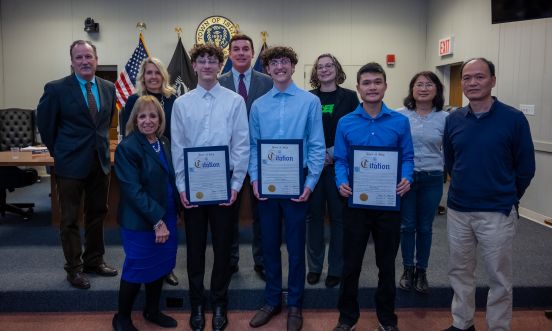 Regeneron Students standing with Town Board Members and Parents