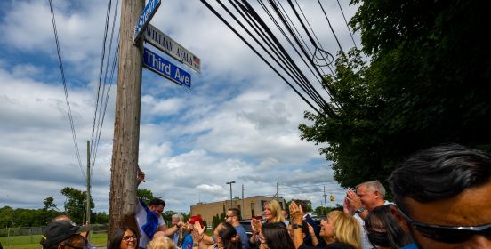 The new street sign is unveiled to the gathered crowd