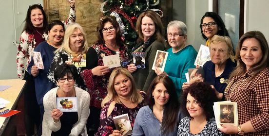 Town Clerk Olga Murray and Clerk's Office staff pose for a group photo holding seasonal greetings cards.
