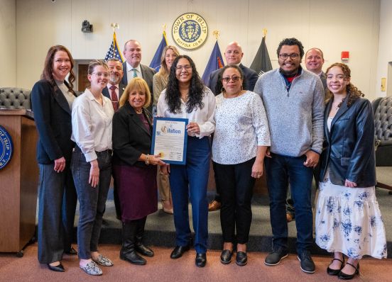 student in group photo with Town Board and award