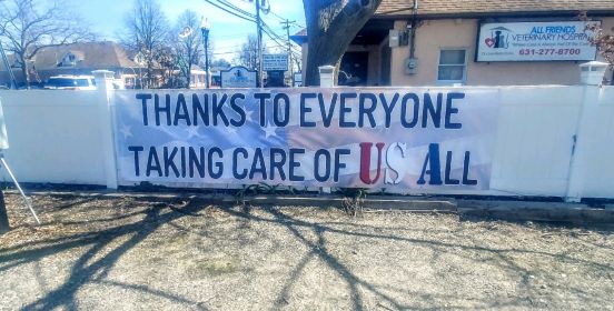 a large poster sign hung on fence with quoted text