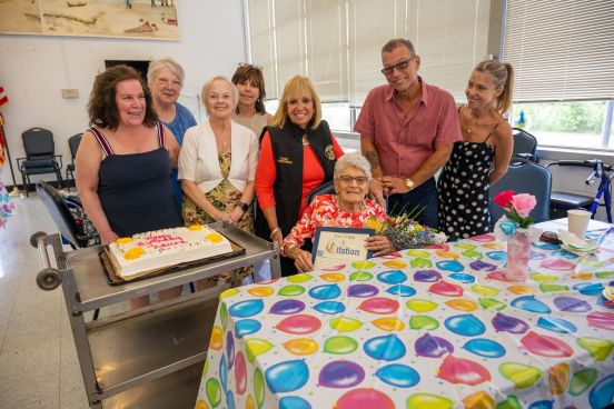 Group photo with birthday girl, family, and Supervisor.