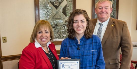 Supervisor Carpenter, DEC Commissioner Martin Bellew and Meghan O'Reilly pose for a photo in the Town Board room as she is presented the Certificate of Recognition.