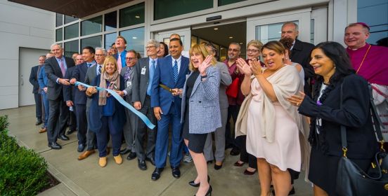 Town Supervisor Angie Carpenter stands outside the facility holding the recently cut ribbon with local officials and hospital staff.